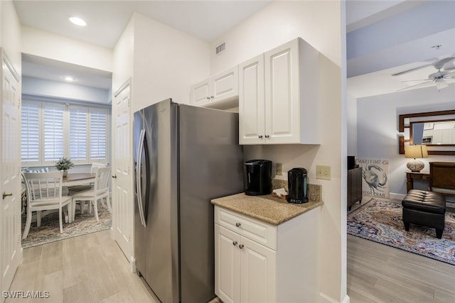 kitchen featuring ceiling fan, light hardwood / wood-style flooring, stainless steel fridge, and white cabinetry