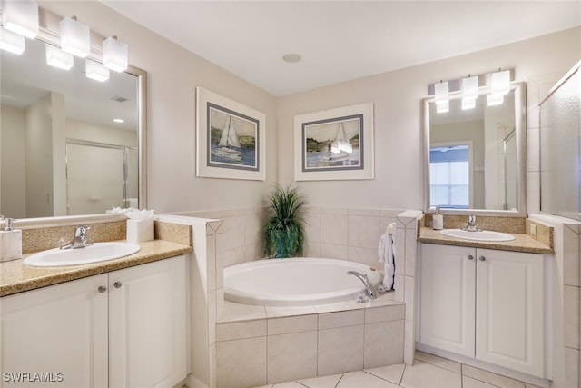 bathroom with tile patterned floors, vanity, and independent shower and bath