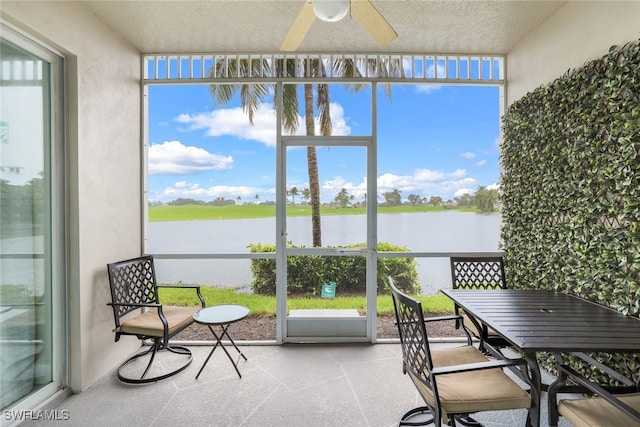 sunroom / solarium with a water view, a wealth of natural light, and ceiling fan