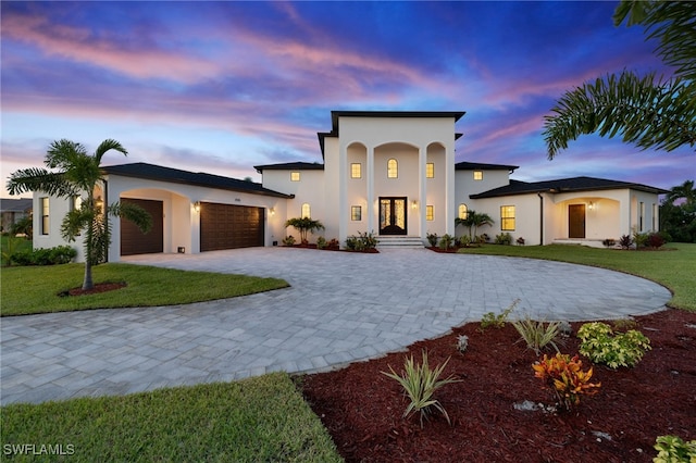 view of front of house with a garage and a yard