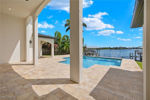 view of pool featuring a water view and a patio