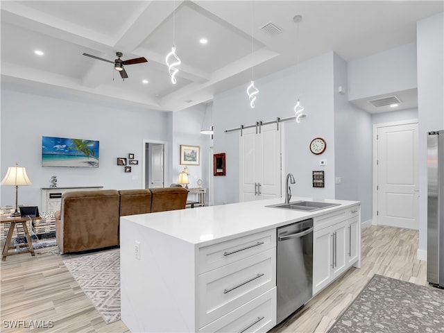 kitchen with pendant lighting, a barn door, stainless steel appliances, and white cabinets