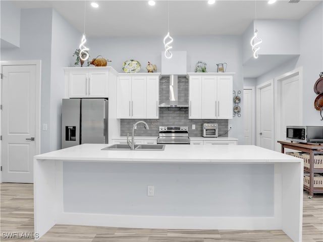 kitchen featuring wall chimney range hood, an island with sink, stainless steel appliances, and pendant lighting