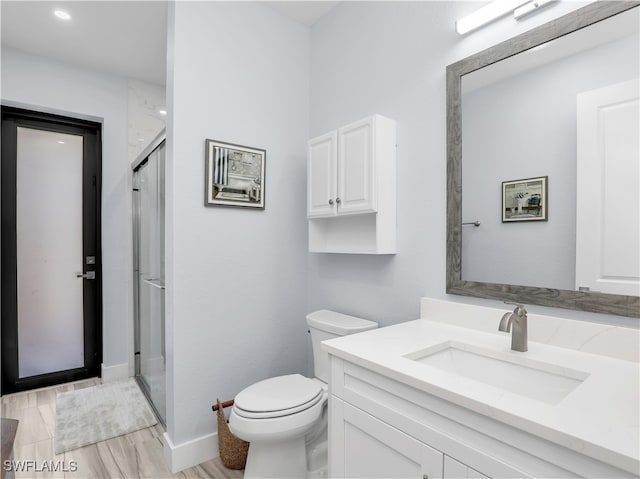 bathroom with vanity, toilet, walk in shower, and wood-type flooring