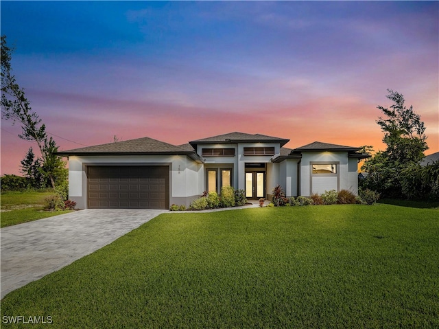 prairie-style home with a yard and a garage