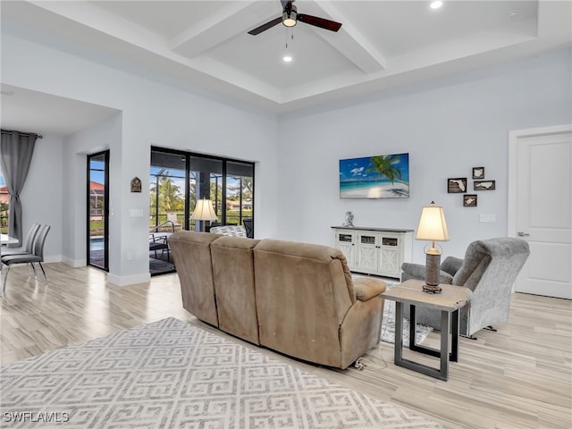 living room with beam ceiling, light wood-type flooring, and ceiling fan