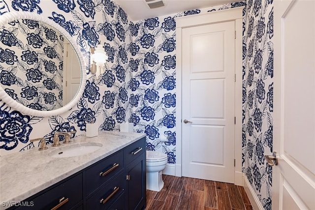 bathroom with vanity, hardwood / wood-style flooring, and toilet