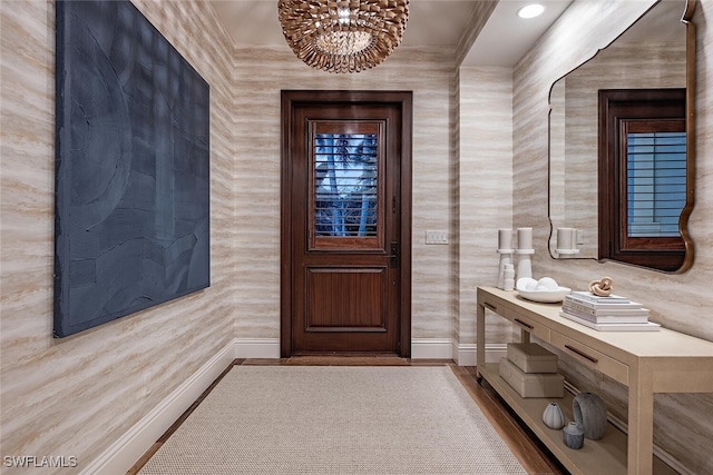 entryway featuring a chandelier, light hardwood / wood-style floors, and crown molding