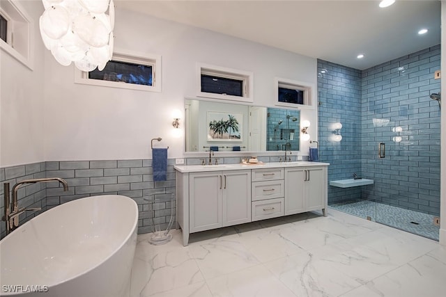 bathroom featuring vanity, shower with separate bathtub, and tile walls