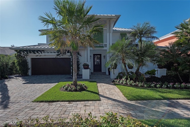 view of front of house featuring a garage and a front lawn