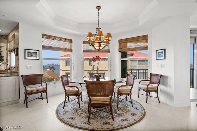 tiled dining area featuring a tray ceiling, crown molding, a notable chandelier, and sink