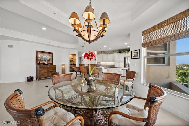 dining space with a raised ceiling, ornamental molding, and a notable chandelier