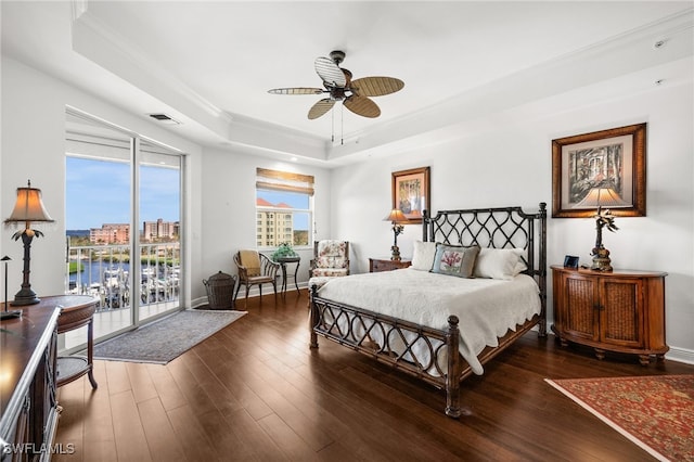 bedroom with access to exterior, ornamental molding, a raised ceiling, ceiling fan, and dark wood-type flooring