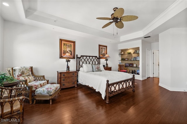 bedroom featuring a raised ceiling, dark hardwood / wood-style flooring, ceiling fan, and crown molding