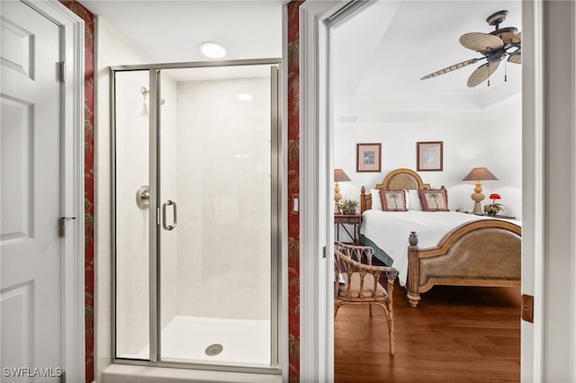 bathroom with hardwood / wood-style floors, ceiling fan, a raised ceiling, and walk in shower