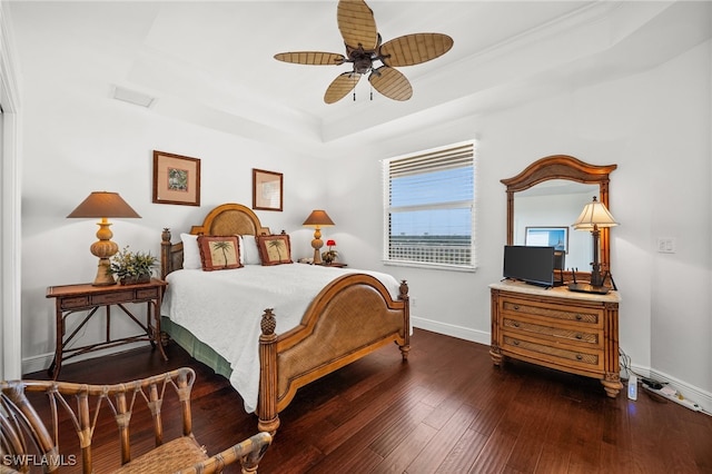 bedroom featuring ceiling fan, dark hardwood / wood-style floors, ornamental molding, and a tray ceiling