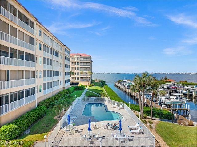 view of pool featuring a water view and a patio