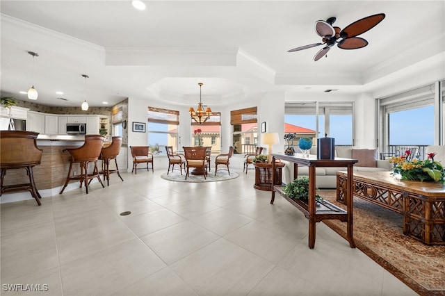 interior space with ceiling fan with notable chandelier, a raised ceiling, and crown molding