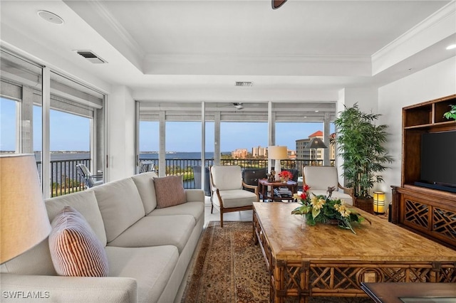 living room featuring a tray ceiling and crown molding