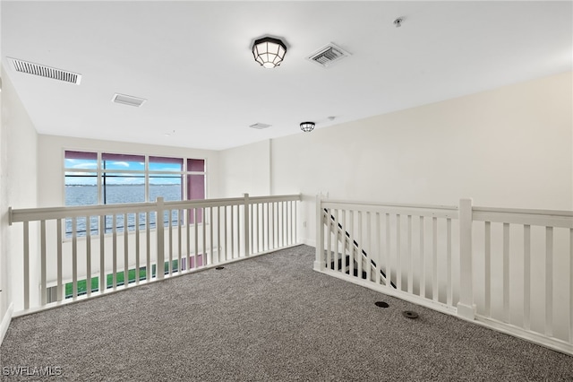 carpeted spare room featuring a water view