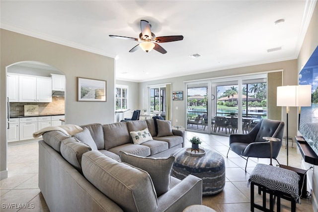 tiled living room with ceiling fan and ornamental molding