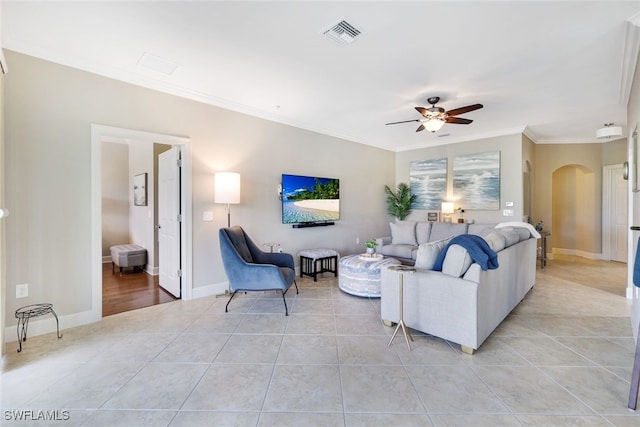 living room featuring light tile patterned floors, ceiling fan, and crown molding