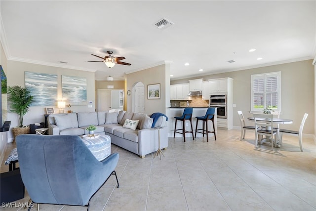 living room featuring ceiling fan, light tile patterned flooring, and ornamental molding