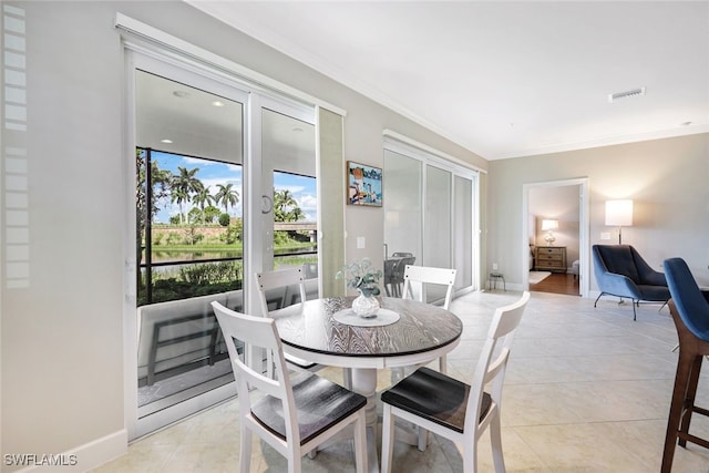 dining space with light tile patterned floors and ornamental molding