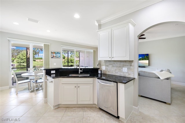 kitchen with dark stone counters, sink, stainless steel dishwasher, decorative backsplash, and white cabinetry