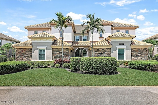 mediterranean / spanish home with a front lawn