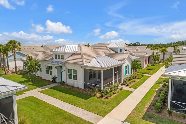 view of front of home with a front lawn and a sunroom