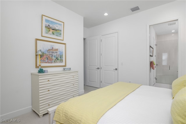 carpeted bedroom with a closet and ensuite bath