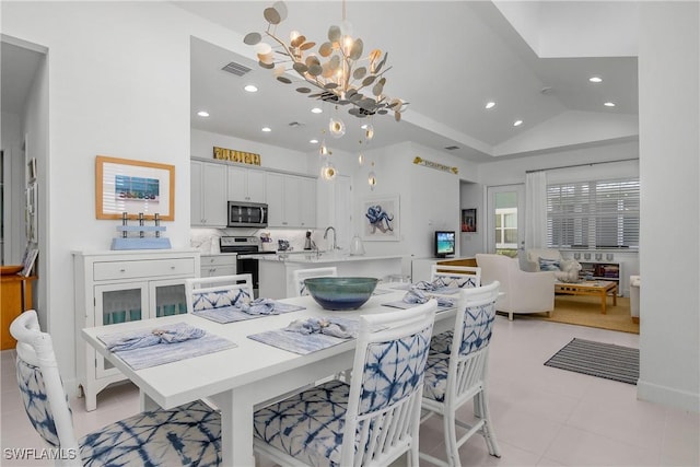 dining room with sink, lofted ceiling, and a notable chandelier