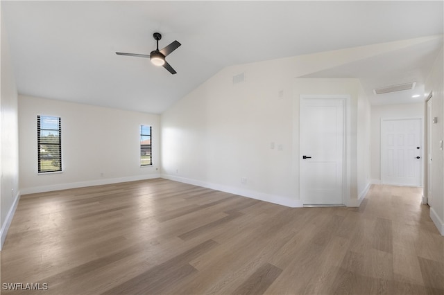 unfurnished room featuring light wood-type flooring, plenty of natural light, and vaulted ceiling