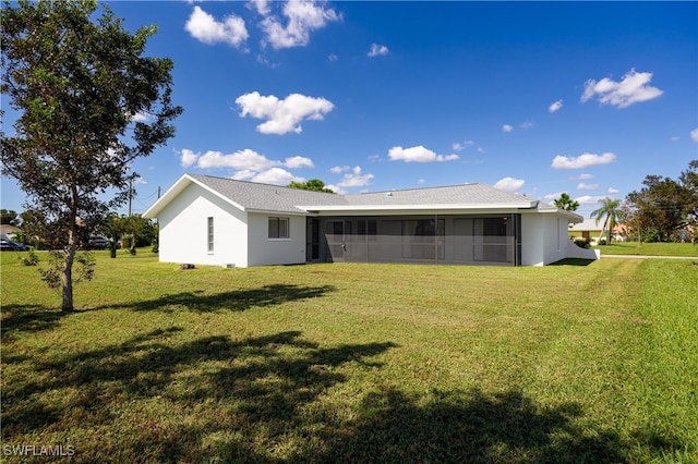 rear view of property featuring a sunroom and a yard