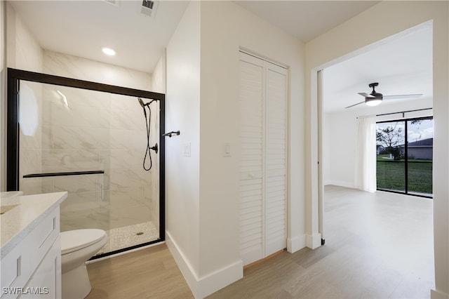 bathroom with ceiling fan, vanity, an enclosed shower, wood-type flooring, and toilet