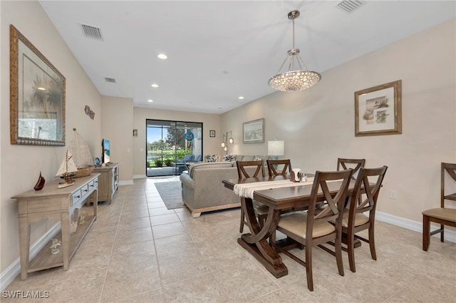 dining room with light tile patterned flooring and an inviting chandelier