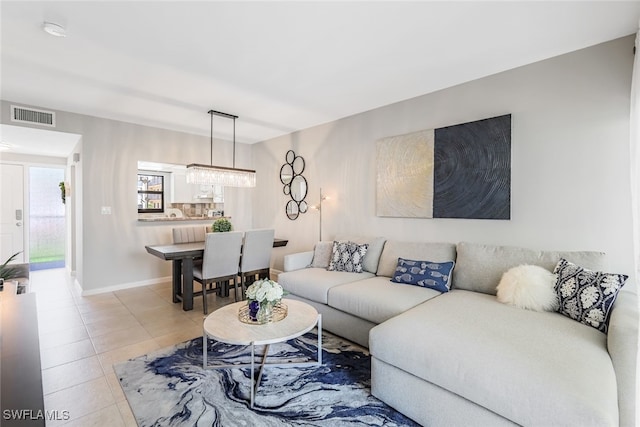 living room featuring a notable chandelier and light tile patterned floors