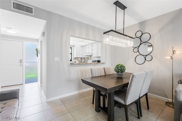 dining room with a notable chandelier and light tile patterned floors