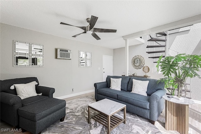 living room featuring ceiling fan, hardwood / wood-style flooring, a textured ceiling, and an AC wall unit