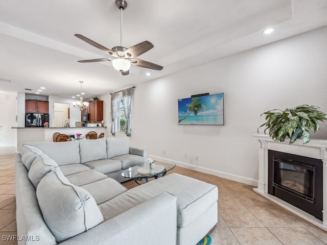 living room with ceiling fan with notable chandelier and light tile patterned floors