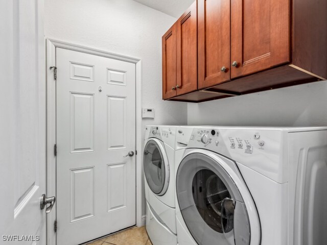 washroom featuring cabinets, separate washer and dryer, and light tile patterned flooring