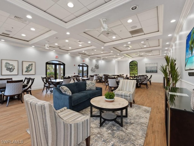 living room featuring ceiling fan, light hardwood / wood-style flooring, crown molding, and coffered ceiling