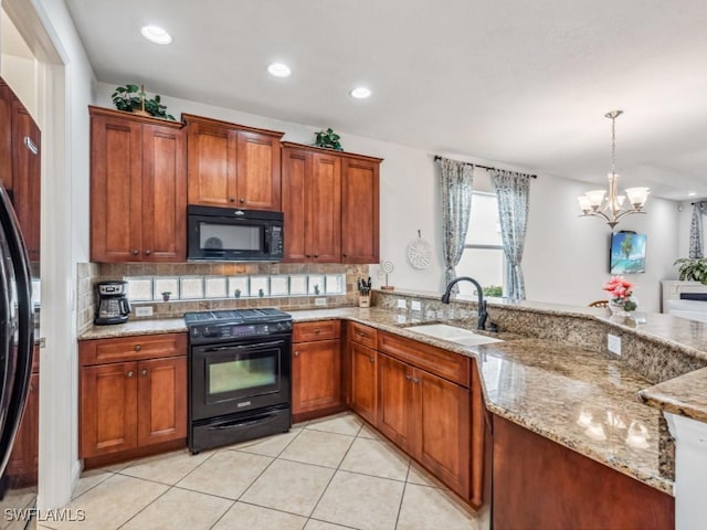 kitchen with a notable chandelier, black appliances, sink, hanging light fixtures, and light stone counters