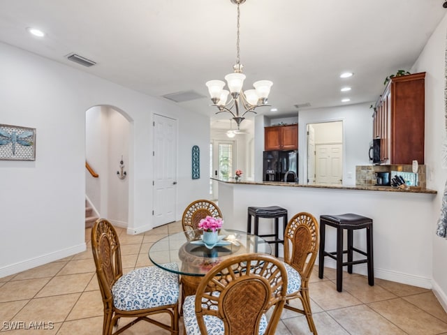 tiled dining area with a notable chandelier