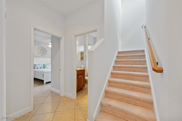 staircase featuring ceiling fan and tile patterned floors