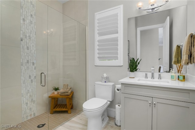 bathroom with tile patterned floors, vanity, an enclosed shower, and toilet