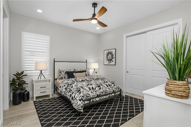 bedroom with light hardwood / wood-style floors, a closet, and ceiling fan