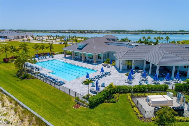 view of pool with a lawn, a patio area, and a water view