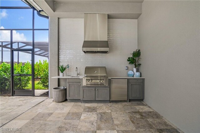 view of patio / terrace featuring glass enclosure, a grill, sink, and an outdoor kitchen